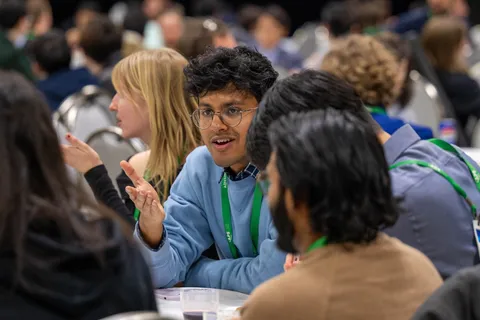 A table of meeting attendees converse at a unit workshop.