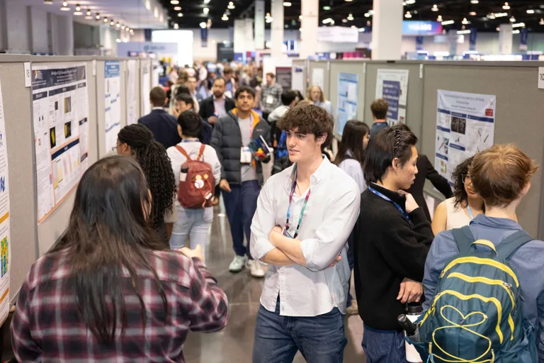 Poster presenters interact with attendees