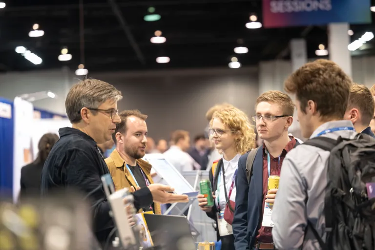An exhibitor talking with attendees. 