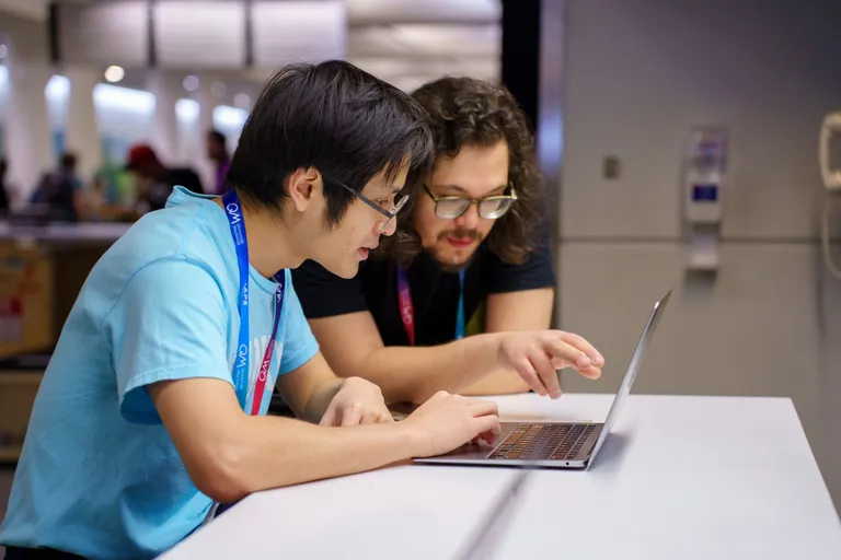 Two people gathered at a laptop.