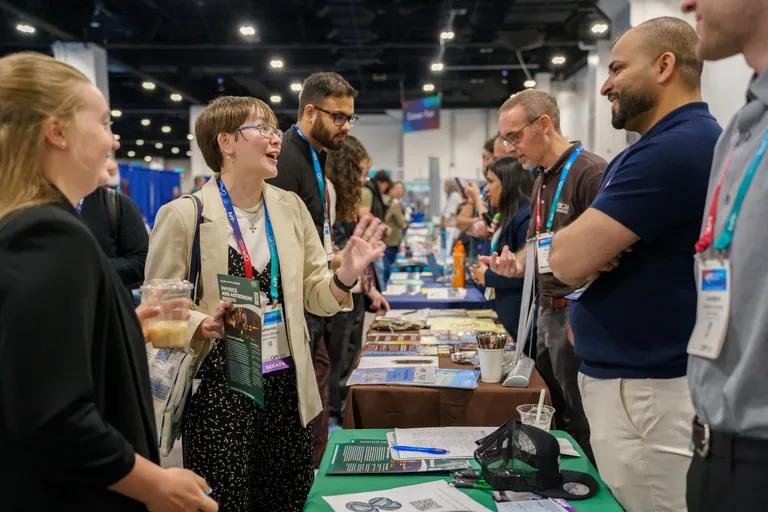 A meeting attendee stops at one of the exhibit booths.