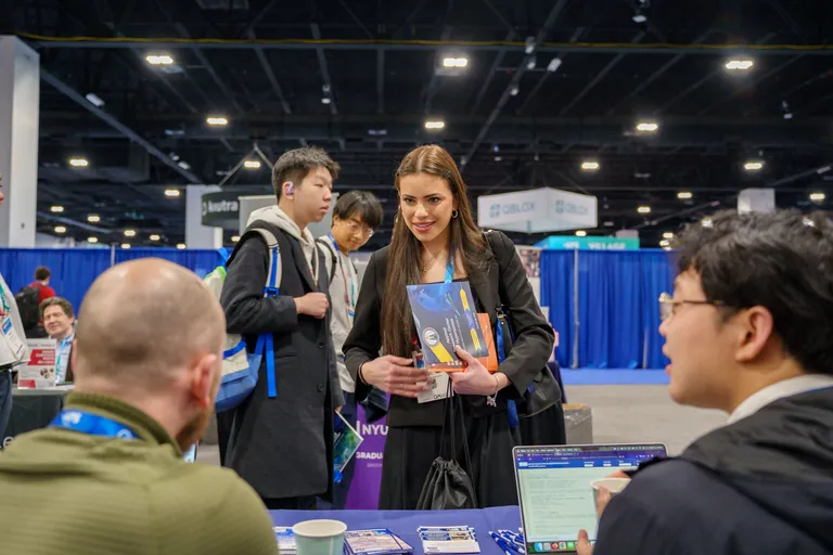A meeting attendee stops at one of the exhibit booths.